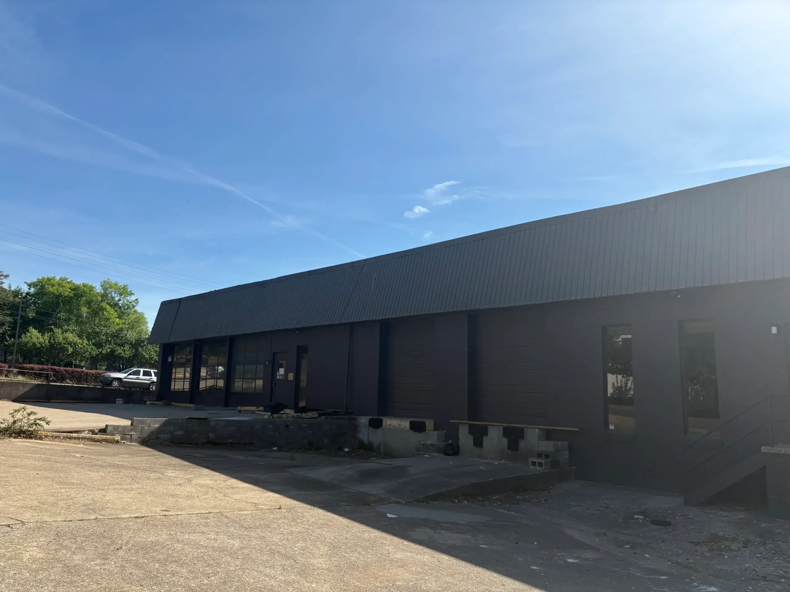 Exterior view of a modern industrial warehouse building with loading dock areas and large commercial space.